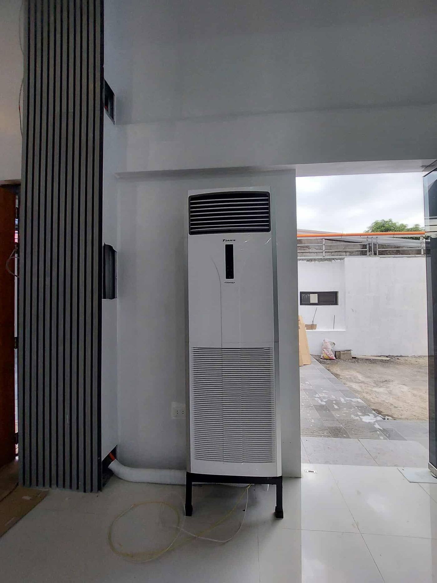 Second Daikin floor-mounted unit near the entrance with the doorway open to the yard