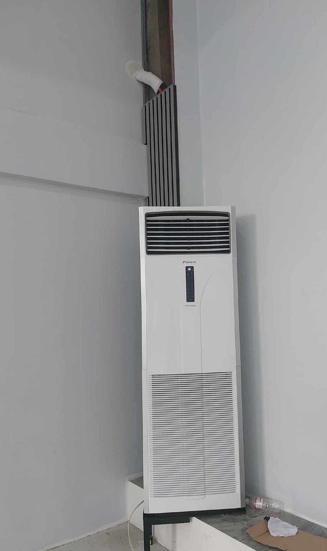 Daikin floor-standing unit against a white wall beside a dark slatted column