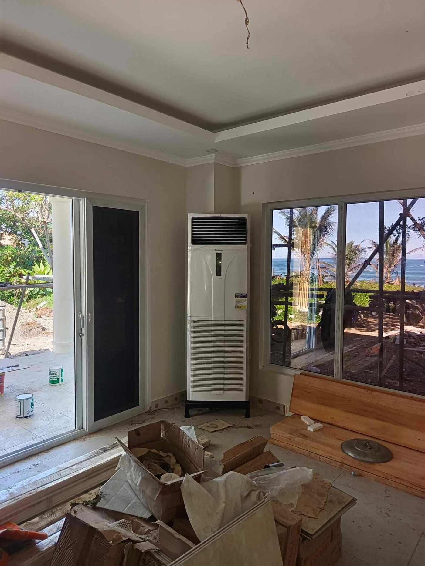 Daikin floor-standing unit in the main room with the sea and palms through the glazing