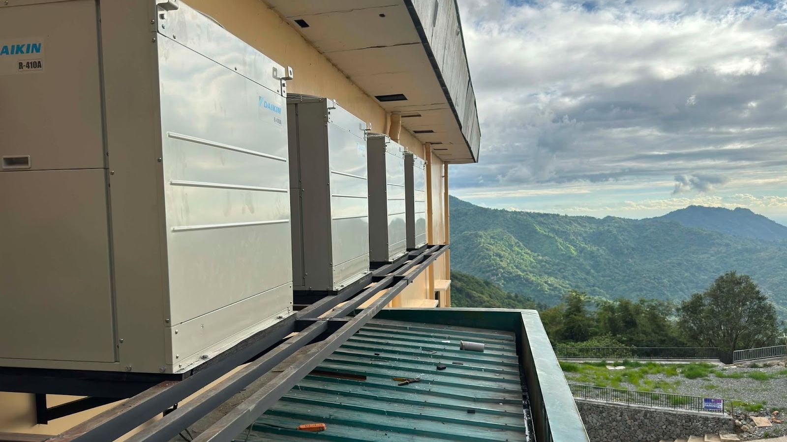 A row of Daikin R-410A VRV condensers on a steel plinth along the building edge, with the Cordillera range behind